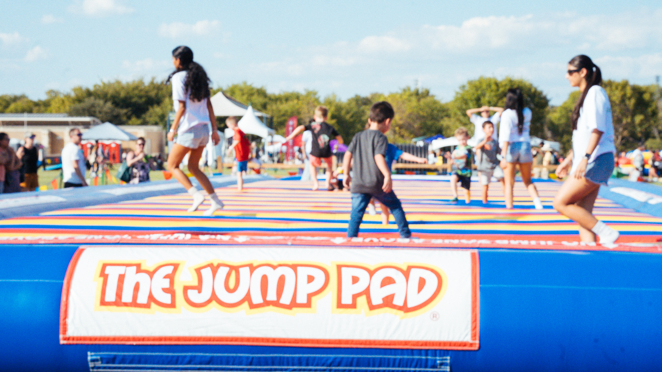 Inflatable jumping pad with kids and adults jumping happily